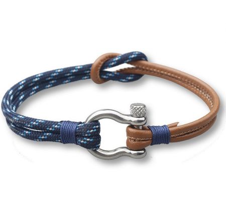 Close-up of the blue cord and brown leather bracelet with its polished silver clasp.