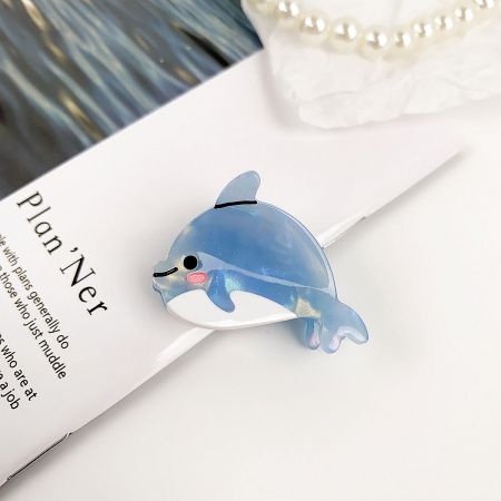 Close-up of the cute blue dolphin hair clip on a planner.