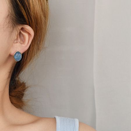 Model showcasing the blue irregular geometric resin stud earring.