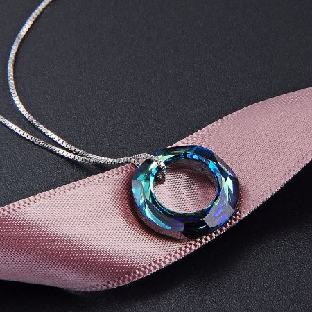 Detailed view of the blue faceted crystal pendant from the sterling silver necklace set.
