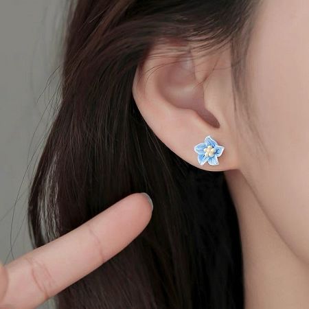 A model wearing the elegant S925 blue flower stud earring to showcase its size and style.