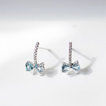 Detailed view of the blue cubic zirconia bow earrings showcasing the intricate silverwork.