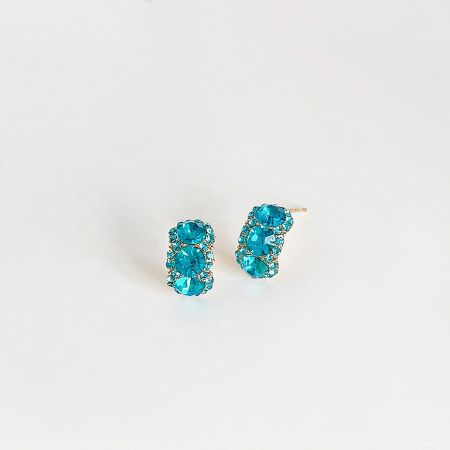 Angled shot of the blue rhinestone earrings highlighting the oval cluster setting.