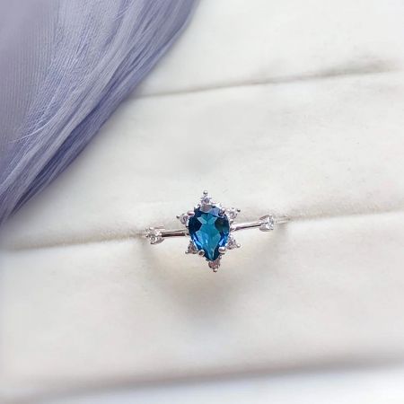 Angled shot of the 925 sterling silver Ocean's Heart ring, emphasizing the brilliance of the blue center stone.
