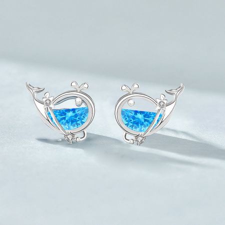 Detailed shot of a unique silver earring with vibrant blue gemstones, highlighting the craftsmanship.