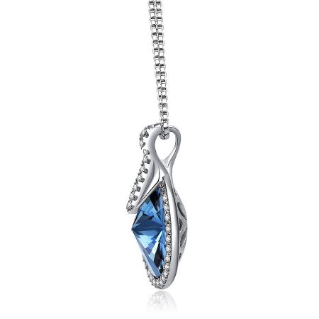 Angled shot of the silver pendant with a large blue gemstone, highlighting its intricate setting.