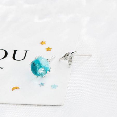 Side view of the sterling silver mermaid tail earring back with a blue-green moonstone stud.