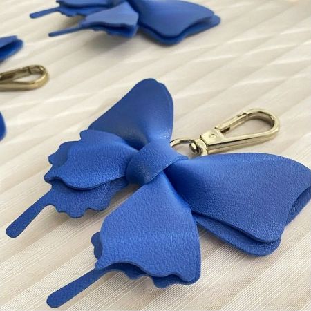 Detailed view of the blue faux leather bow keychain.
