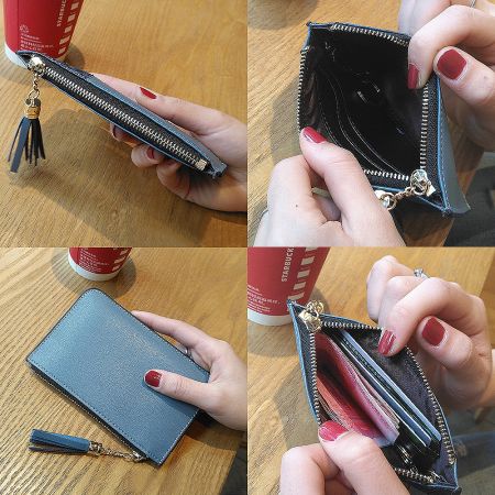 Detailed view of the blue leather mini wallet with a smooth gold zipper and a decorative tassel keychain.