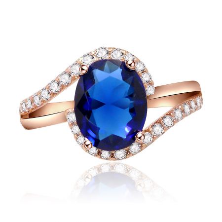 Oval Sapphire Zirconia Swirl Ring - Front view of the Oval Sapphire Zirconia Swirl Ring, showcasing the large oval blue sapphire centerpiece surrounded by sparkling diamonds on a rose gold band.