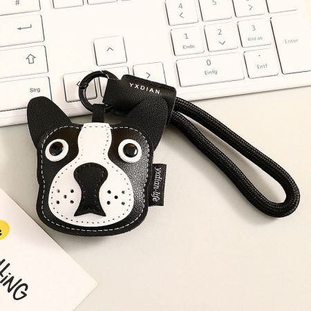 Close-up of the black Boston Terrier leather keychain with a branded strap.