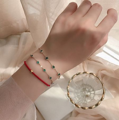 Close-up of the 925 Sterling Silver Emerald Bracelet on a wrist, showcasing its elegant design and sparkling green gemstones.