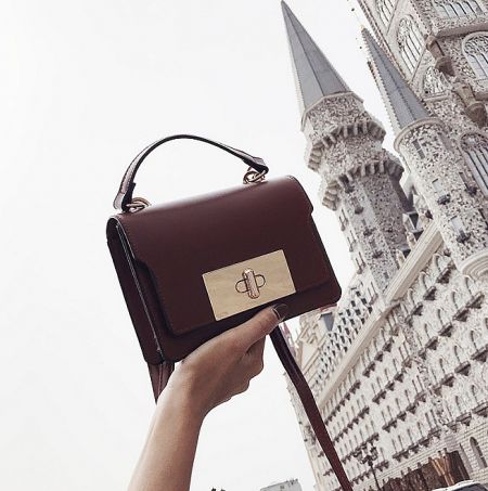 Lifestyle shot of the brown leather purse in an elegant setting.