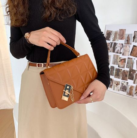 Detailed view of the brown PU leather handbag, showcasing its fine texture and expert craftsmanship.