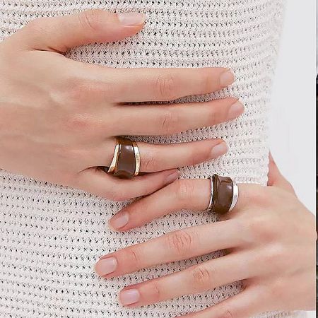 Model's hands showcasing the adjustable chocolate enamel cuff rings in both gold and silver tones.