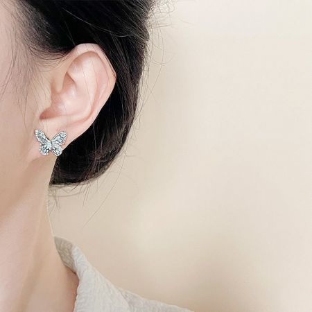 Model wearing the mint green enamel butterfly stud earring.