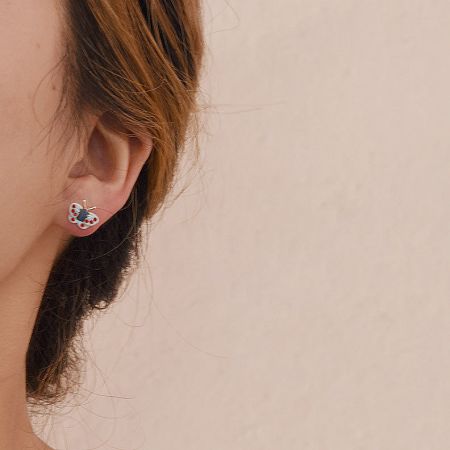 Side view of a model showcasing the blue enamel butterfly earring.