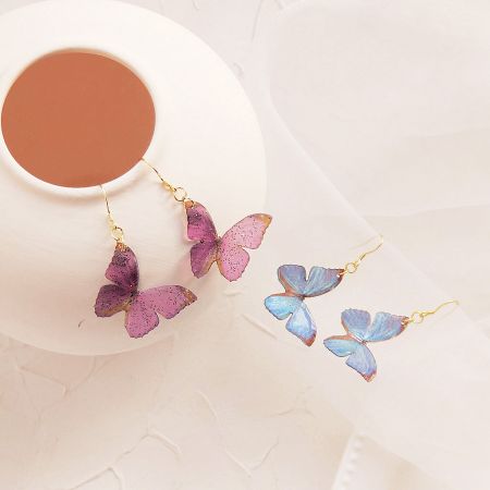 Two pairs of butterfly earrings showcasing the different color options.