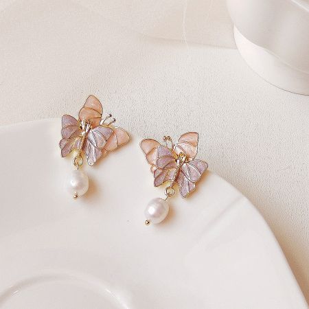 Front view of the pair of purple butterfly earrings with freshwater pearl drops on a clean white background.