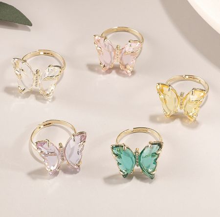 Collection of adjustable butterfly rings available in various gemstone colors.