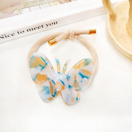 Detailed view of a single butterfly hair accessory showcasing its intricate blue and white marbled design.