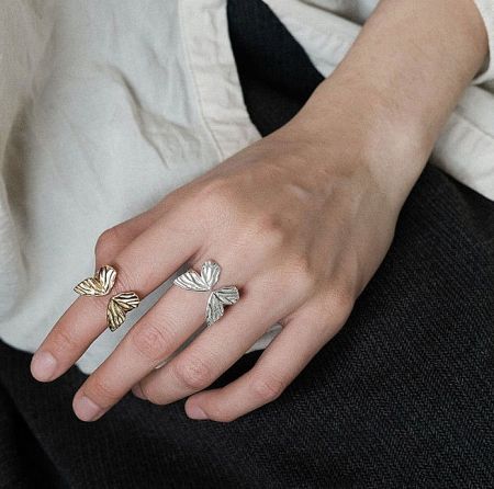Two sterling silver butterfly rings with intricate wing details displayed side-by-side