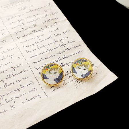 The cat painting stud earrings presented on a handwritten letter, adding a personal touch.