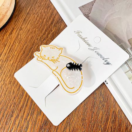 A white cat-shaped hair clip featuring a delicate fish design and pearl embellishments.