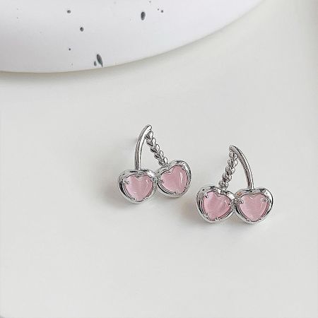 Detailed view of the cherry-shaped earrings with pink opal stones on a white background.