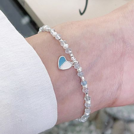 A beautiful bracelet with clear glass beads and a blue and white enamel heart charm.