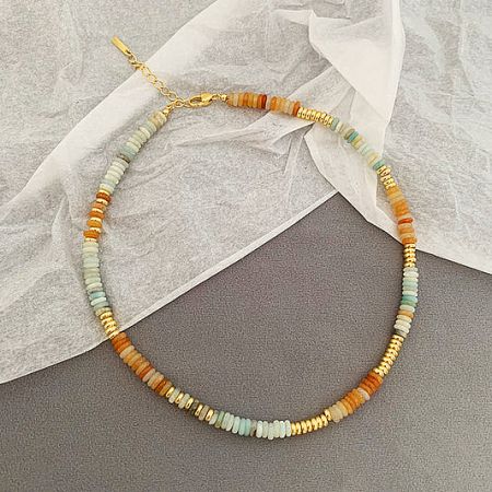 Close-up of a colorful bohemian-style beaded costume necklace with gold accents.