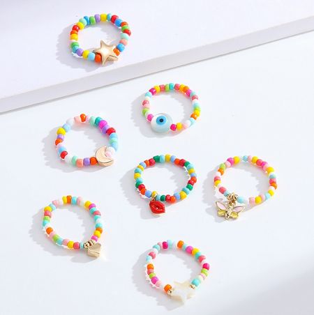 Beaded Ring With Charms - A vibrant collection of colorful beaded rings and bracelets with assorted charms, showcasing the customizable style of JR Fashion Accessories' beaded jewelry.