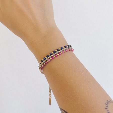 Two colorful beaded bracelets stacked on a wrist, demonstrating a layered look.