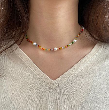 Model wearing the trendy chic colorful beaded pearl necklace to showcase its summer style.