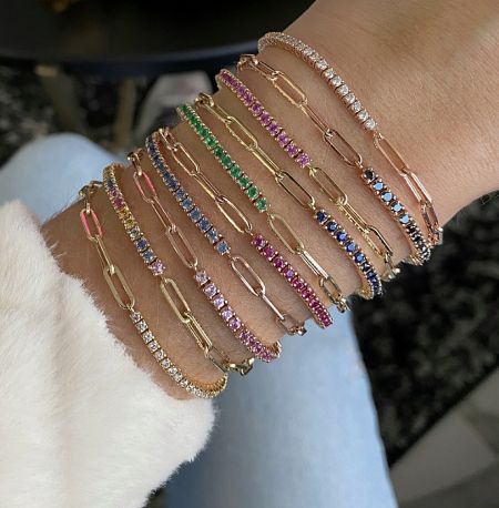A collection of colorful tennis bracelets worn on a wrist, showcasing various styles and designs.