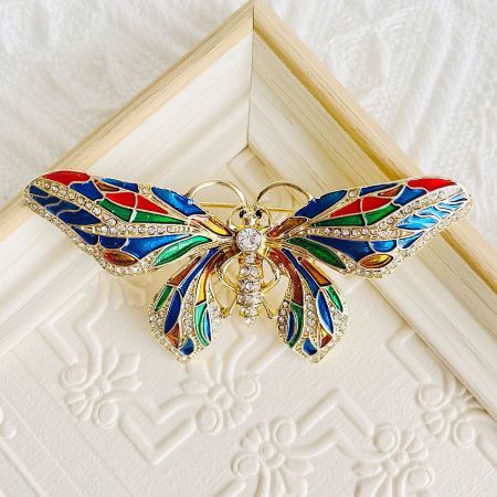 Detailed view of the butterfly brooch with colorful stained glass-like wings.