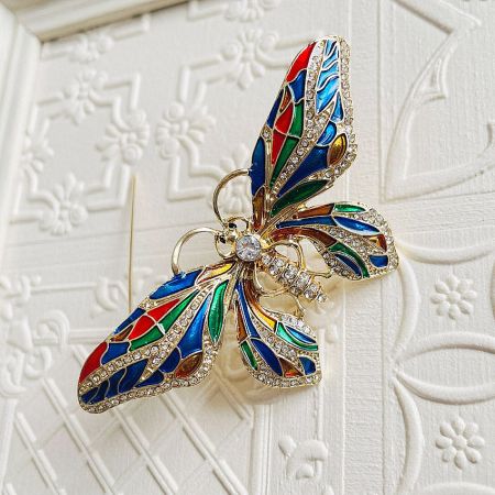 Close-up of the butterfly brooch highlighting the intricate rhinestone and enamel work.