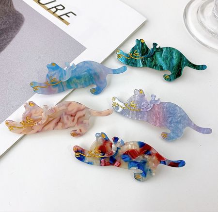 Playful collection of colorful cat-shaped hair clips with marbled patterns.