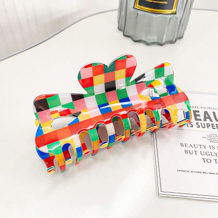 Close-up of a single multicolored hair clip featuring a bold checkered design.