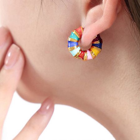 Side profile of a woman wearing a colorful enamel hoop earring, demonstrating its appearance when worn.