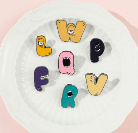 A collection of colorful enamel letter pins with different expressions, ideal for personalization.