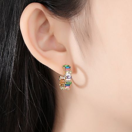 Model wearing the colorful gemstone hoop earrings to show scale and style.