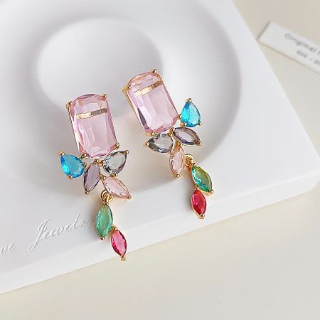 Full set of gold-plated earrings with various colored gemstones on a display.