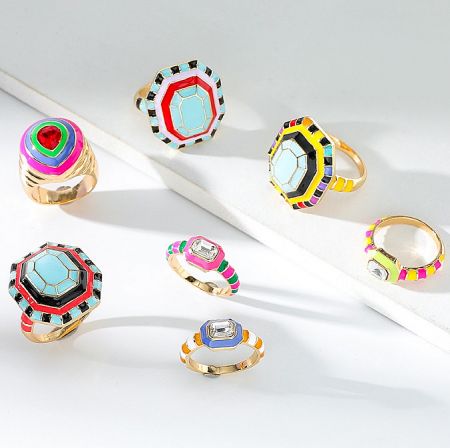 Gold-Plated Enamel Ring Collection - A vibrant collection of seven gold-plated enamel rings by JR Fashion Accessories, showcasing various colorful designs and octagonal centerpieces.