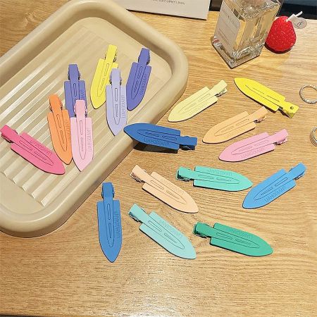 A vibrant arrangement of no-crease hair clips in various pastel colors on a wooden surface.