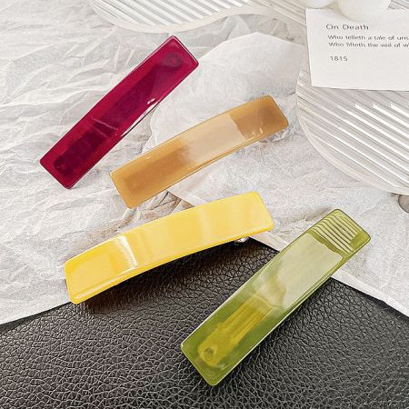 Four colorful rectangle hair clips arranged in a row.
