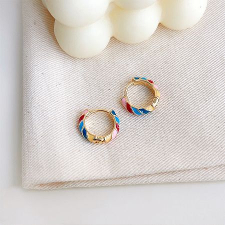 Colorful enamel hoop earrings with a geometric pattern on a gold base.