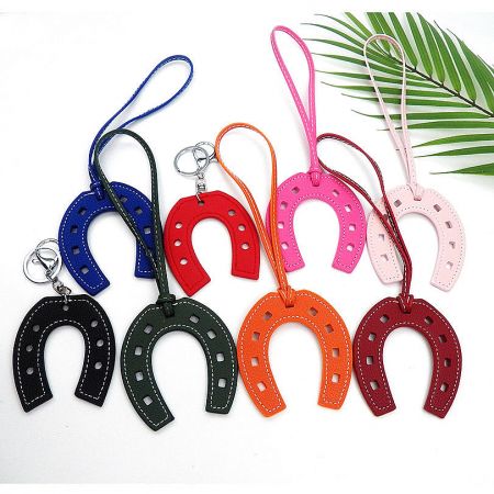 A collection of colorful horseshoe-shaped PU leather keychains in various shades.