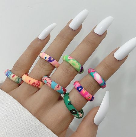 Cartoon Flowers Soft Glue Ring - A model's hand showcasing a set of colorful Cartoon Flowers Soft Glue Rings, highlighting their vibrant designs and comfortable fit.