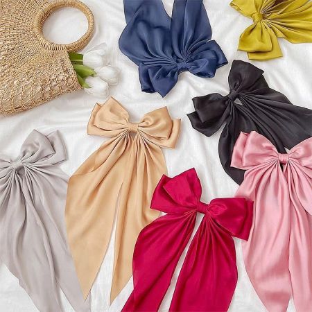 A vibrant collection of long-tail bow hair clips in multiple colors.